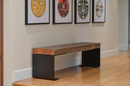 a table in front of a wall with framed art at Island Luxury Oceanside Estate in Saanichton