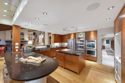a large kitchen with wooden cabinets and a black counter top at Island Luxury Oceanside Estate in Saanichton