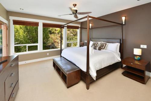 a bedroom with a canopy bed and windows at Nature's Gate Executive Estate in Victoria