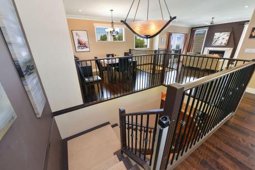 a room with a staircase with chairs and a chandelier at Nature's Gate Executive Estate in Victoria