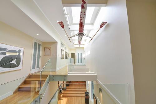 a hallway with white walls and stairs in a building at Island Luxury Oceanside Estate in Saanichton