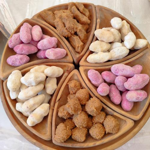 a group of different colored cookies on a wooden plate at Guest House NAZIRA in Kazarman