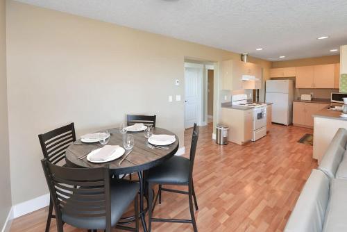 a dining room with a table and chairs and a kitchen at Nature's Gate Executive Estate in Victoria
