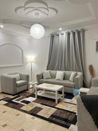 a living room with two couches and a table at نسمة كيان للشقق المخدومة in Jeddah