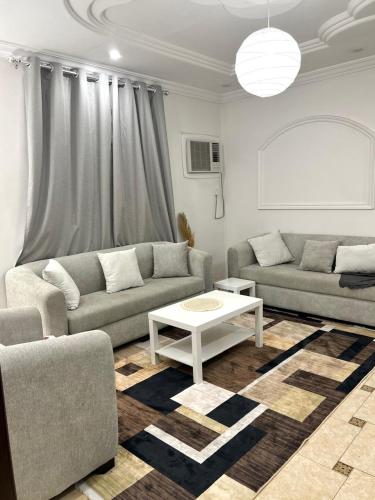 a living room with two couches and a coffee table at نسمة كيان للشقق المخدومة in Jeddah