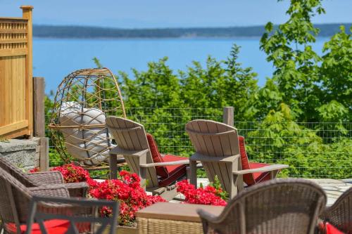 a group of chairs sitting on a patio with flowers at Gulf Island View Suite in Chemainus