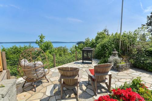 a patio with chairs and a table and a lantern at Gulf Island View Suite in Chemainus