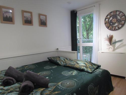 une chambre avec un lit et une horloge au mur dans l'établissement Escapade à deux ou en télétravail Studio calme avec Parking gratuit, WiFi rapide, proche ligne 14 et Paris centre, à Villejuif