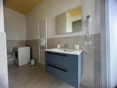 łazienka z błękitną umywalką i toaletą w obiekcie Maison Merci w mieście Pedemonte