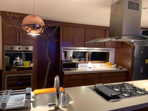 a kitchen with a sink and a stove top oven at Casa del bosque in Jilotepec