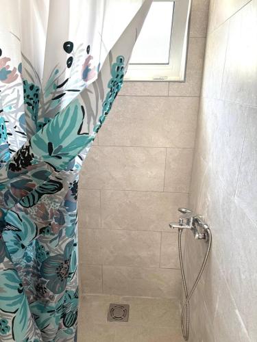 a shower with a shower curtain in a bathroom at Tatjana apartman blue in Sutomore