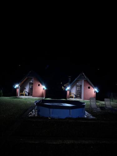 Una fotografía nocturna de una casa con piscina en el patio. en Rest&peace homes, en Mojkovac