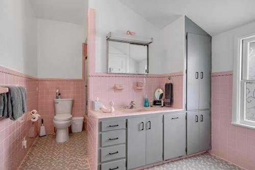ein rosafarbenes Bad mit einem Waschbecken und einem WC in der Unterkunft St Augustine "Pink House" Sleep 12, 6 Bd, 3Bth, Steps to Historic St Augustine Center & All Tourist Attractions, Restaurants, Cafes, Backyard, Porch in St. Augustine