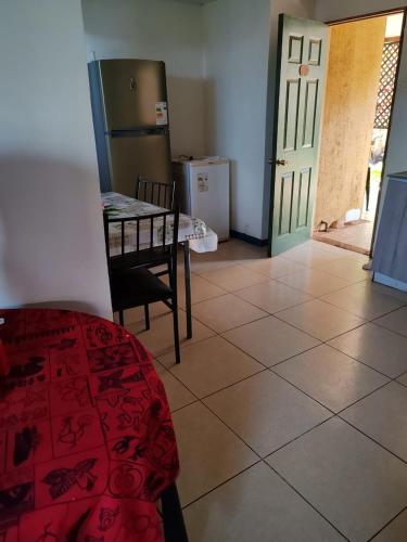 a living room with a table and a refrigerator at Cabañas Iisi in Hanga Roa