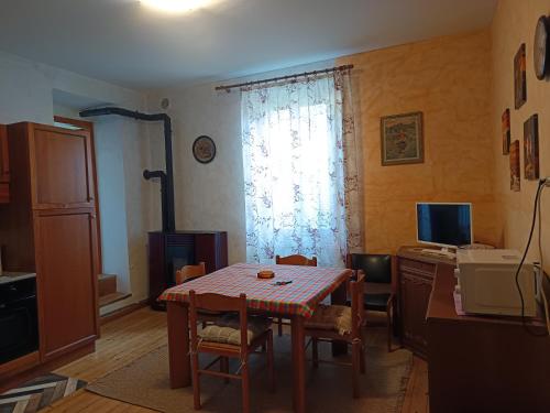 a dining room with a table and a desk with a computer at Il Pellicano in Rovereto