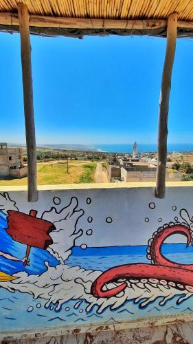 a window with a painting on the side of a wall at Azour House in Taghazout
