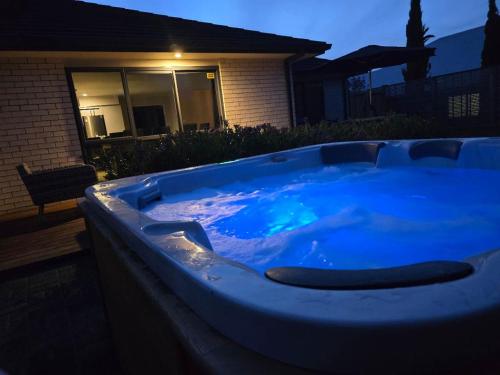 un grand bain à remous bleu en face d'une maison dans l'établissement Forest Lakes Luxury, à Rotorua