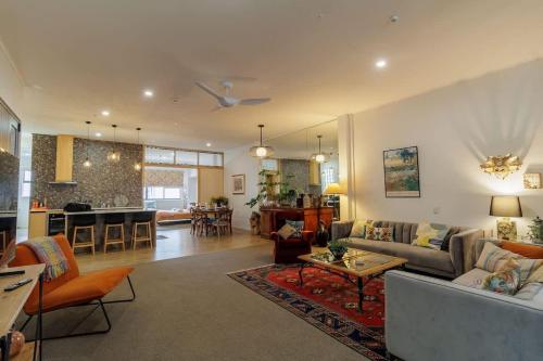 a living room with a couch and a table at Inn Tutanekai - Central City Chic 3 Bedroom 2 Bathroom Apartment in Rotorua