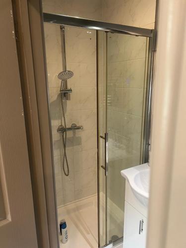 a shower with a glass door next to a sink at Fully Furbished Entire Flat 2 in Woolwich