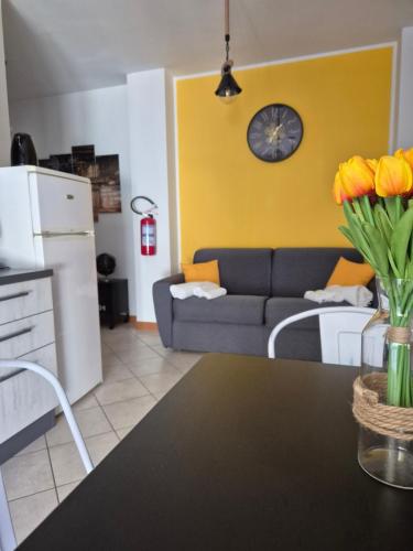 a kitchen and living room with a couch and a clock at Factory 219 Apartment Guidonia in Guidonia