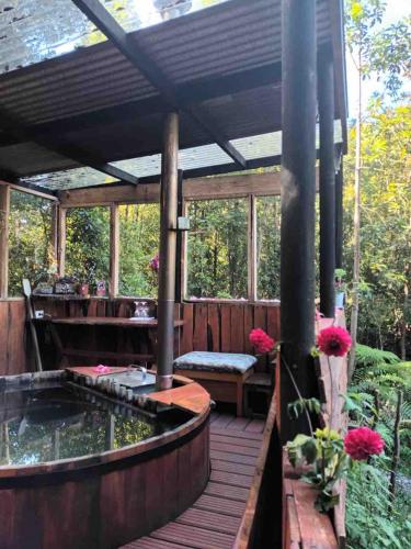 a wooden deck with a koi pond and a pergola at Blue Cabin - La Herradura 