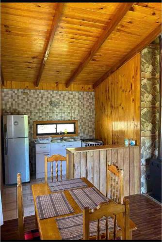 a kitchen with a table and a white refrigerator at Blue Cabin - La Herradura 