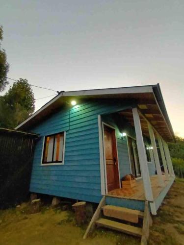 a small blue house with a porch and a door at Blue Cabin - La Herradura 