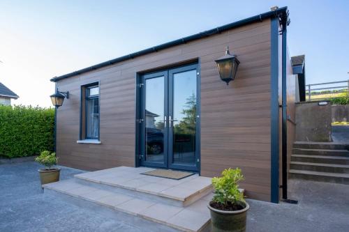 a house with a glass door and some plants at Southview Cottage in Boardmills