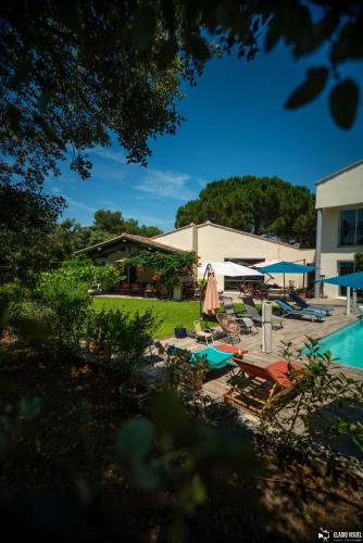 - une piscine avec des chaises et des parasols à côté d'un bâtiment dans l'établissement La Villa Coucou, à Nîmes