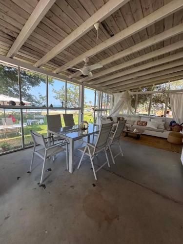 a dining room with a table and chairs and windows at Sea Side Caravan in Vourvourou
