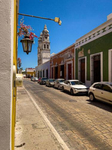 a city street with a clock tower and cars parked at Hotel Boutique Casa Lanz XVII in Campeche
