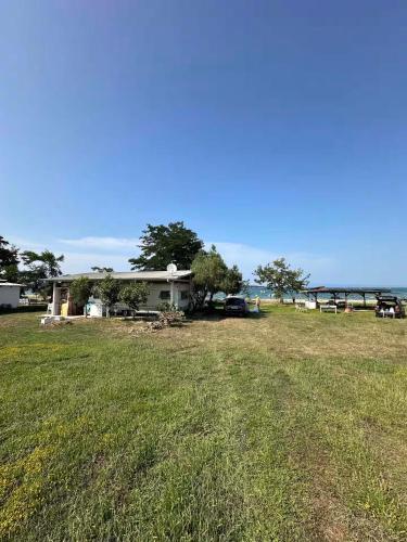 a yard with a house and a grass field at Sea Side Caravan in Vourvourou