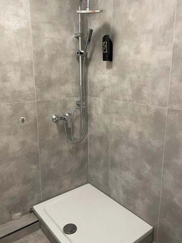a bathroom with a shower with a white sink at Haven Hotel - Wuppertal in Wuppertal