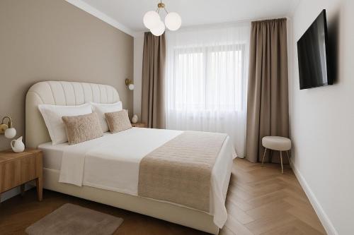a white bedroom with a white bed and a window at Luxury Stay in Brăila