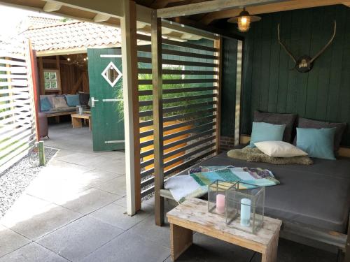 Kawasan patio atau luaran di De Goudvink 7-persoons, overdekte hottub en loungebank, finse sauna, wifi, sunshower