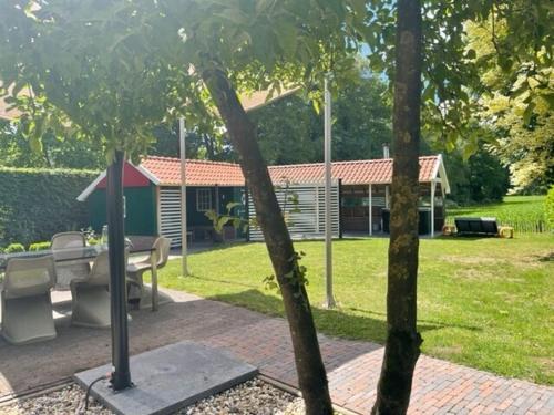Taman di luar De Goudvink 7-persoons, overdekte hottub en loungebank, finse sauna, wifi, sunshower