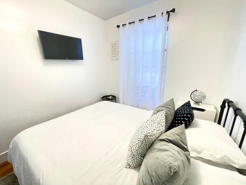 a bedroom with two beds and a flat screen tv at Madison Ave Oasis in New York