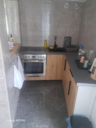 a small kitchen with a stove and a sink at Apartman hukanovic in Bosanska Krupa