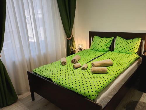a bed with green polka dot sheets and pillows at Bucarest old center in Văleni