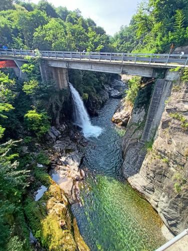 a bridge over a river with a waterfall at Casa Pepita in San Bernardino Verbano