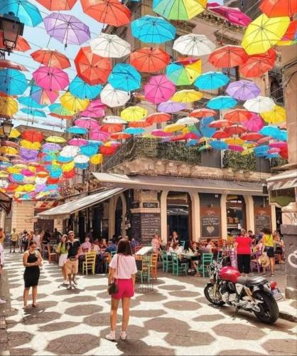 a bunch of colorful umbrellas hanging from a building at Asmundo Palace Suites & Spa in Catania