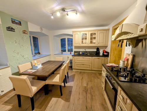 a kitchen with a wooden table with chairs and a stove at Domaine du KleinHammer in Windstein