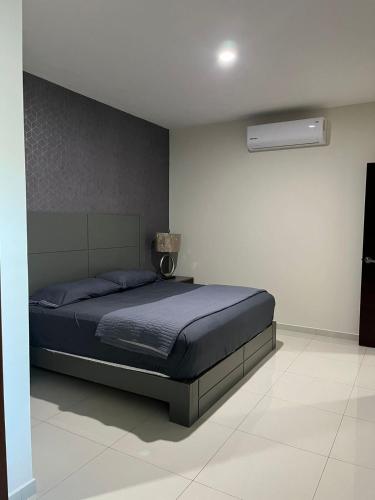 a bedroom with a bed with a blue comforter at QB Departamento de lujo en Quintas espacioso y confortable in Culiacán
