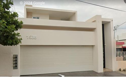 a white house with a garage door at QB Departamento de lujo en Quintas espacioso y confortable in Culiacán