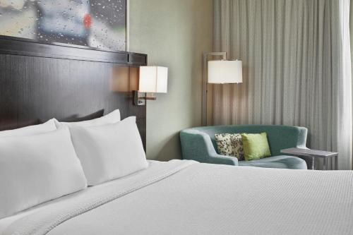 a bed and a chair in a hotel room at Courtyard by Marriott Portland City Center in Portland