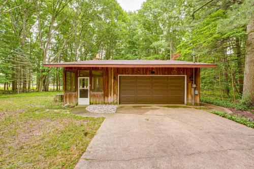 a small house with a garage in the woods at Less Than 1 Mi to Lake Michigan Peaceful Cabin with Yard! in Whitehall