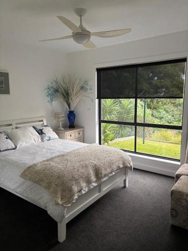a bedroom with a bed and a large window at Quiet haven in Forster