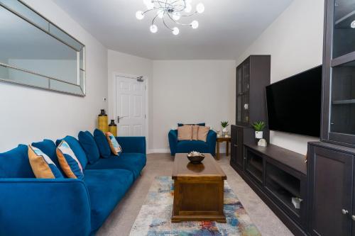 a living room with a blue couch and a tv at Dublin Premier Homestay in Ráth Cúil