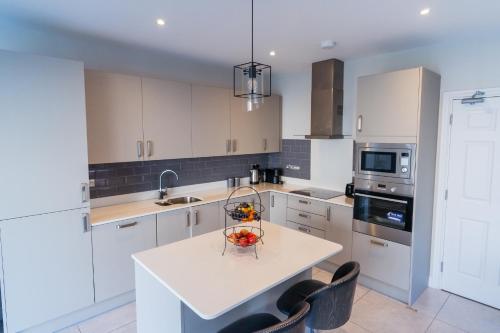 a kitchen with a table with a bowl of fruit on it at Dublin Premier Homestay in Ráth Cúil