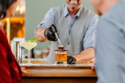 a man is making a drink at a bar at The Westin Charlotte in Charlotte